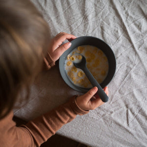 baby eating cereal in a blue bowl