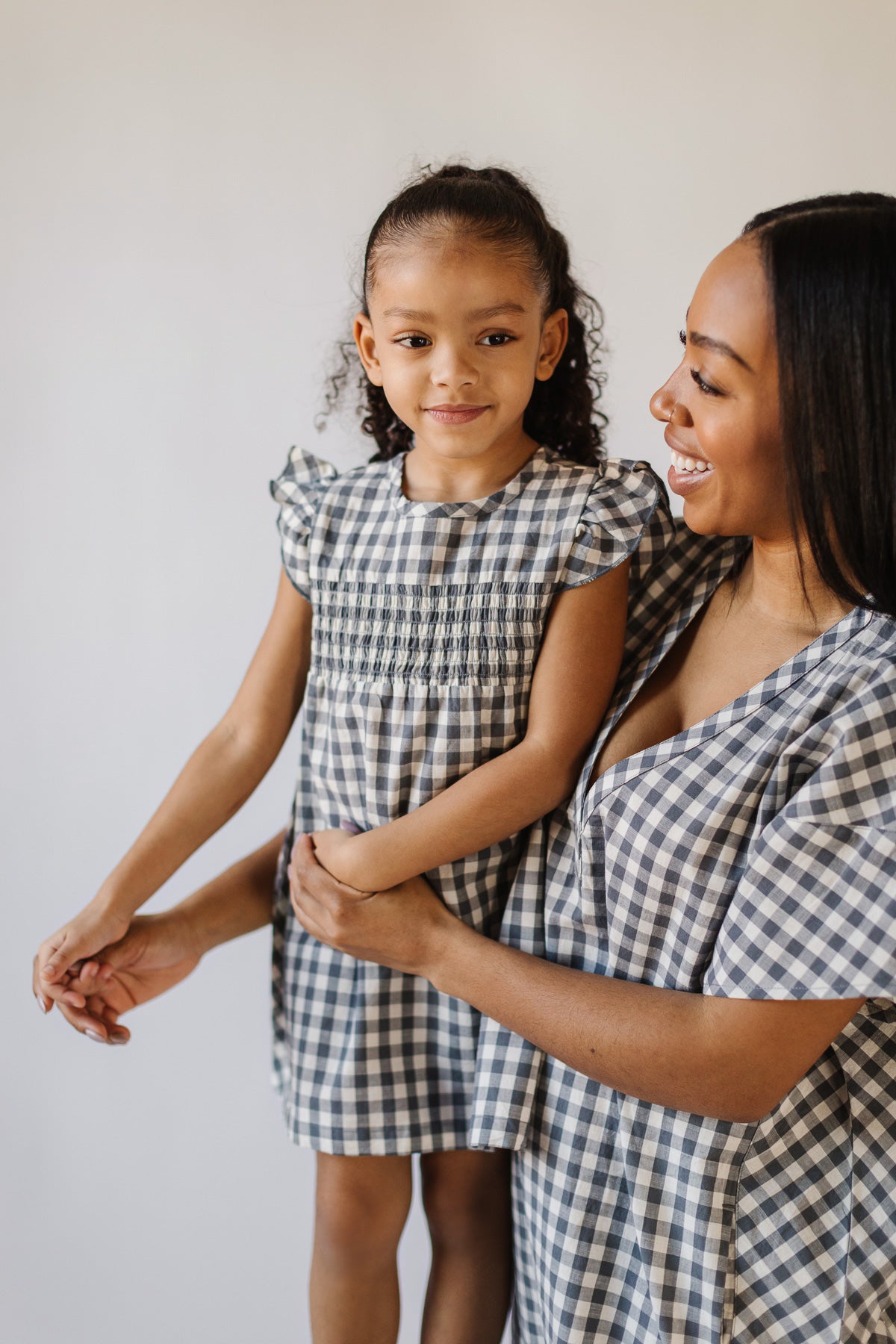 mom and girl wearing matching check mate dresses