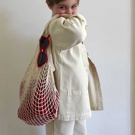 Kid in creamy jacket holding a bag